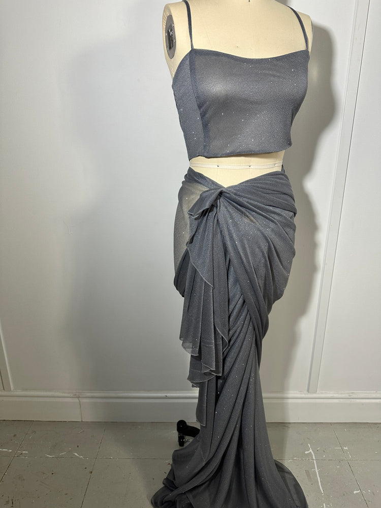 "A stunning silver glitter saree with spaghetti straps, combining elegance and sparkle in one captivating ensemble. The shimmering fabric and delicate spaghetti straps create a mesmerizing and glamorous look, perfect for any glamorous occasion."