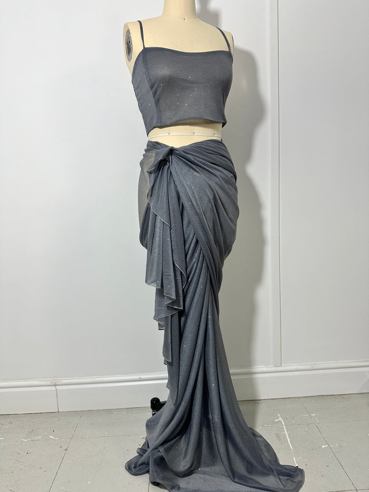 "A stunning silver glitter saree with spaghetti straps, combining elegance and sparkle in one captivating ensemble. The shimmering fabric and delicate spaghetti straps create a mesmerizing and glamorous look, perfect for any glamorous occasion."