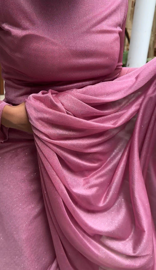 "An elegant dark pink long sleeve saree with a touch of sparkle, perfect for special occasions. The saree features a glittery fabric that adds a glamorous touch to the overall look."